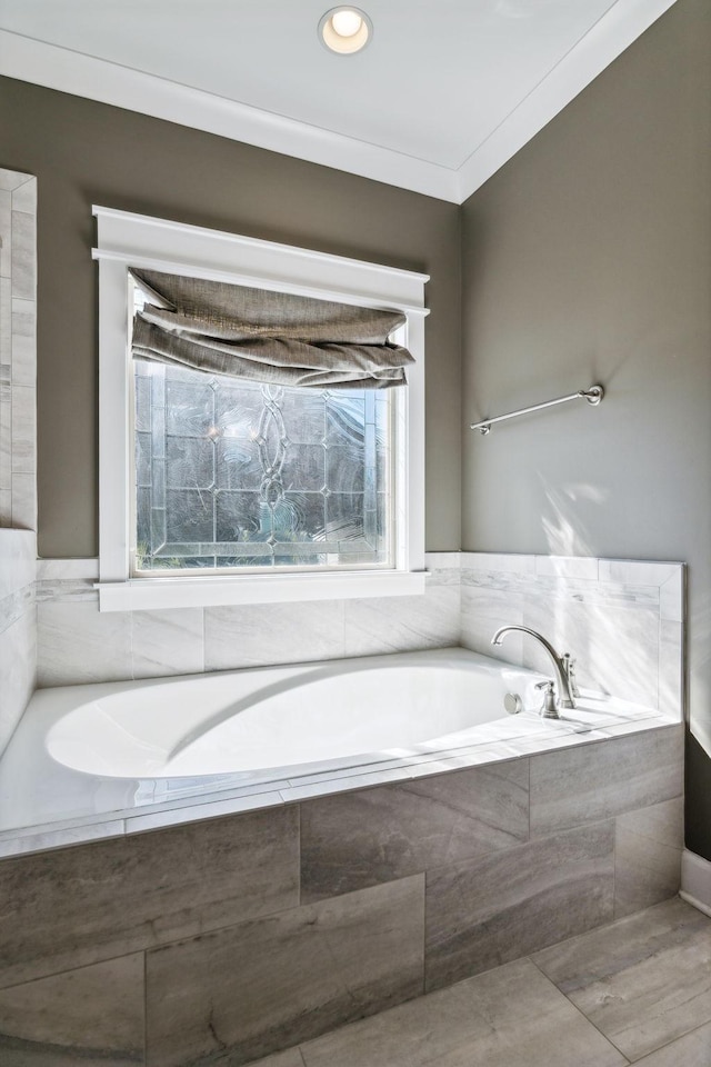 bathroom featuring a relaxing tiled tub and crown molding