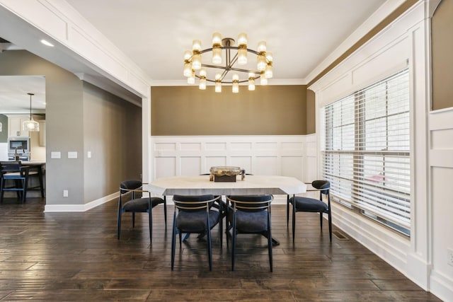 dining area with crown molding, dark wood-type flooring, and a chandelier