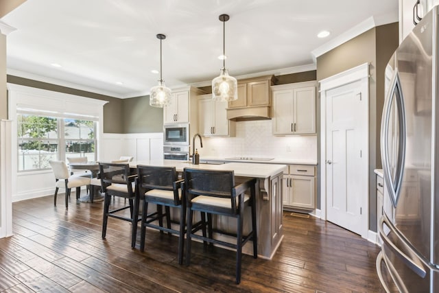 kitchen featuring dark hardwood / wood-style floors, sink, hanging light fixtures, stainless steel appliances, and a center island with sink