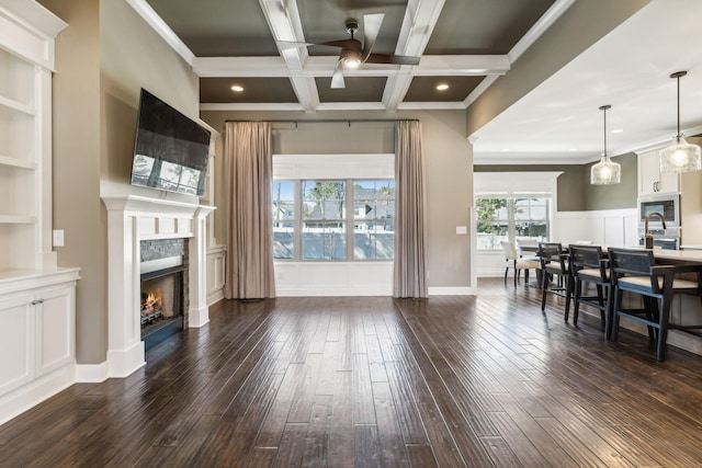 living room with dark hardwood / wood-style flooring, ornamental molding, coffered ceiling, beam ceiling, and built in shelves