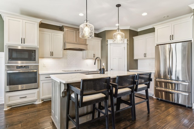 kitchen featuring sink, appliances with stainless steel finishes, a center island with sink, dark hardwood / wood-style flooring, and decorative light fixtures