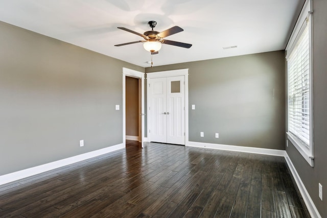 unfurnished room with ceiling fan and dark hardwood / wood-style flooring