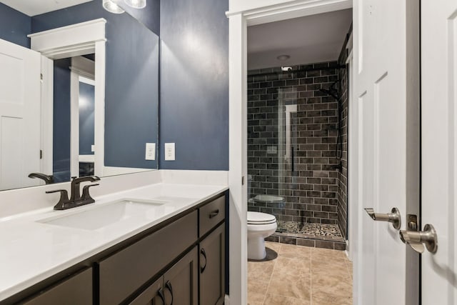 bathroom featuring vanity, a shower with door, and toilet