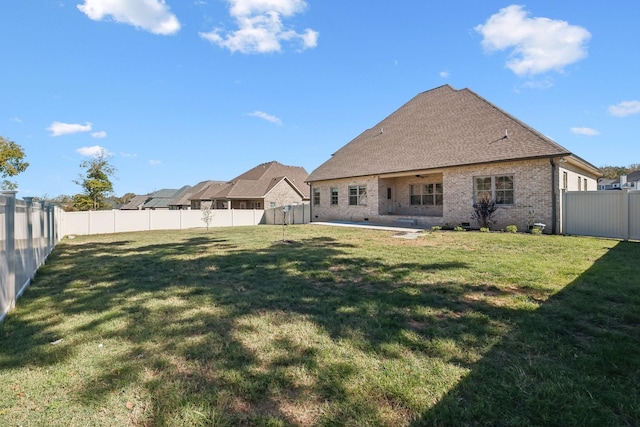 rear view of property featuring a patio area and a lawn