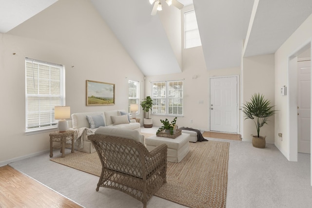 living room with ceiling fan, high vaulted ceiling, and light carpet