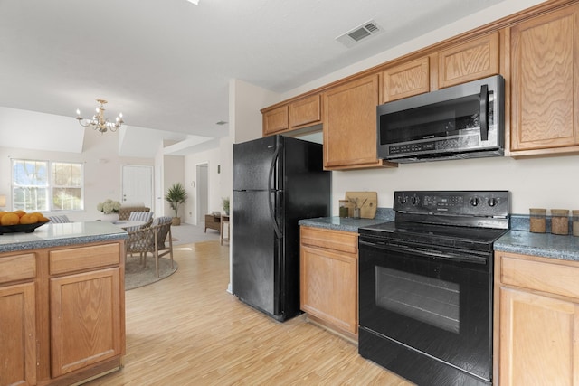 kitchen featuring light hardwood / wood-style flooring, black appliances, and a chandelier