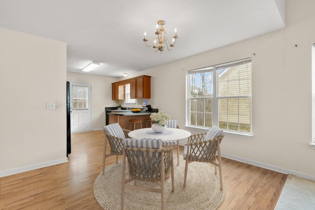 dining area featuring an inviting chandelier and light hardwood / wood-style flooring