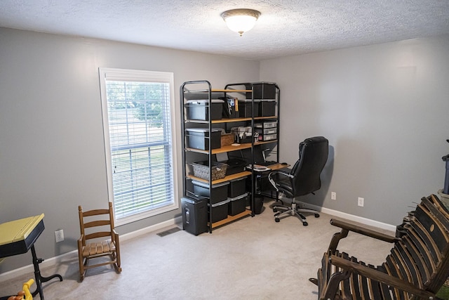 home office featuring carpet and a textured ceiling