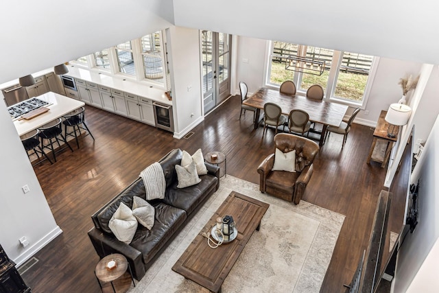 living room with hardwood / wood-style flooring, vaulted ceiling, and beverage cooler