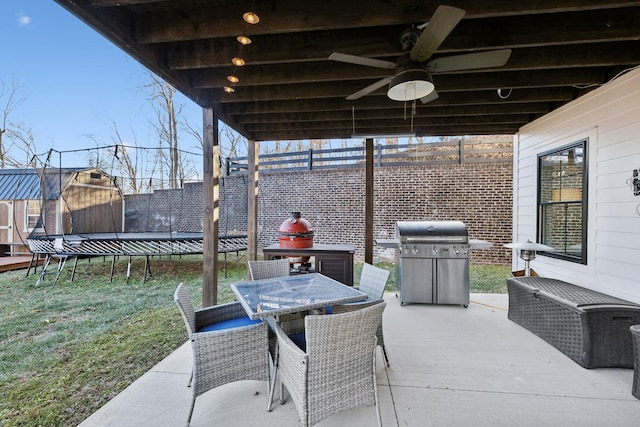 view of patio / terrace with a grill, a trampoline, and a storage shed