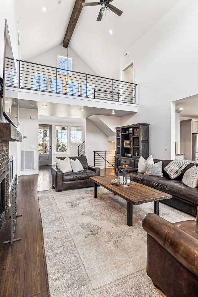 living room with hardwood / wood-style flooring, ceiling fan, high vaulted ceiling, and beam ceiling