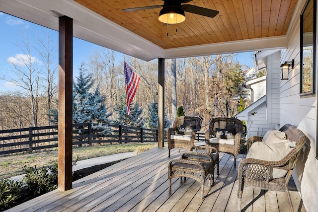 wooden terrace featuring an outdoor living space and ceiling fan