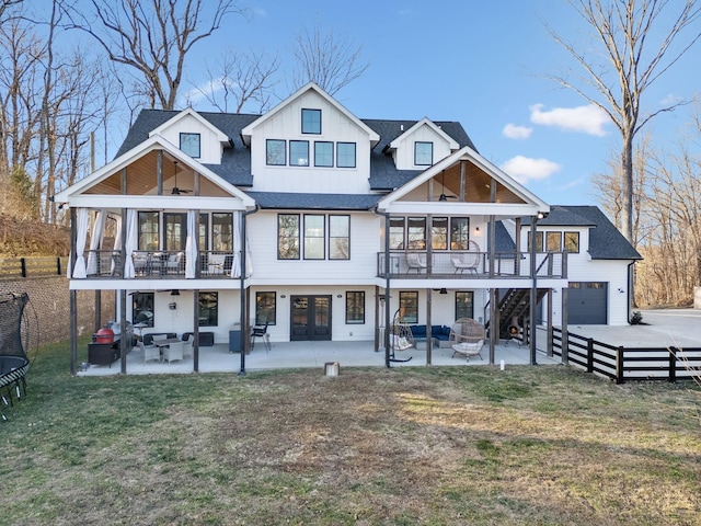 rear view of house featuring an outdoor fire pit, a garage, a patio, and a lawn