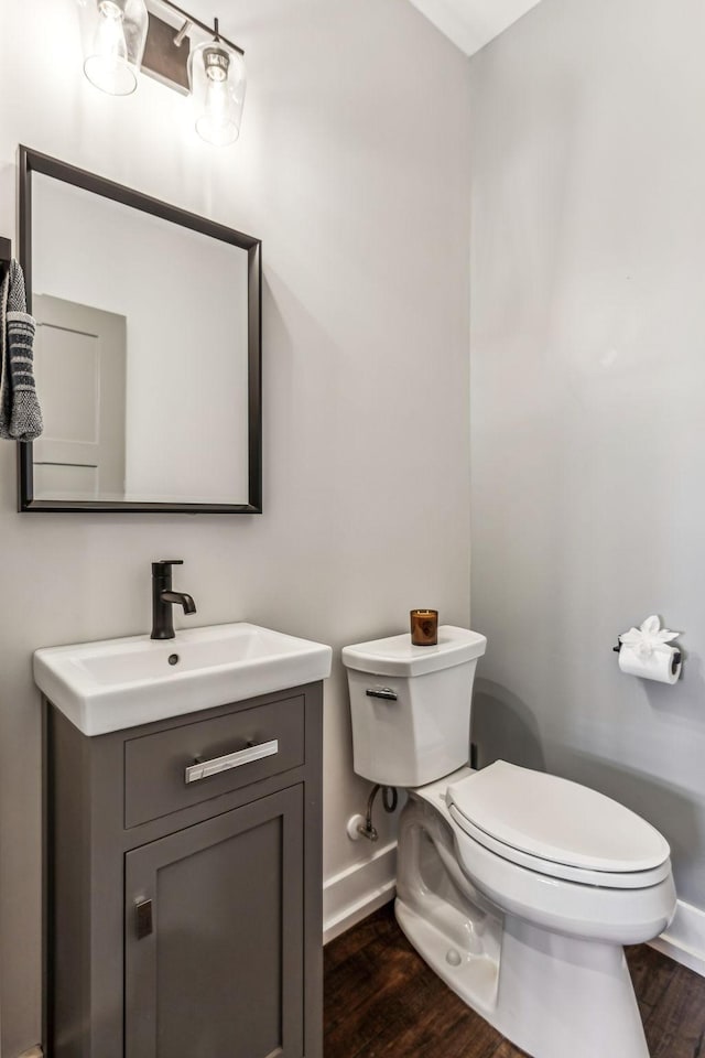 bathroom with hardwood / wood-style flooring, vanity, and toilet