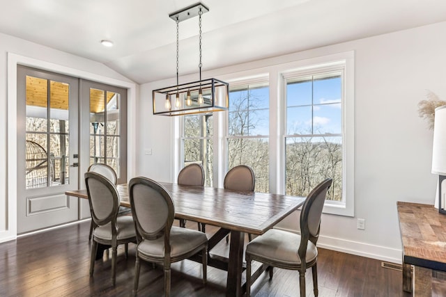 dining area featuring lofted ceiling and dark hardwood / wood-style floors