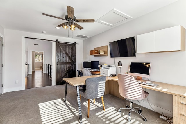 office with ceiling fan, a barn door, and dark carpet