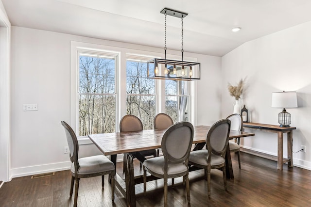 dining space with an inviting chandelier and dark hardwood / wood-style floors