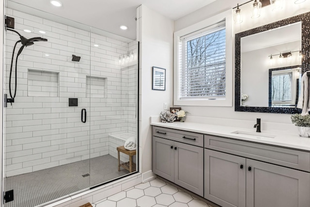 bathroom featuring a shower with door and vanity