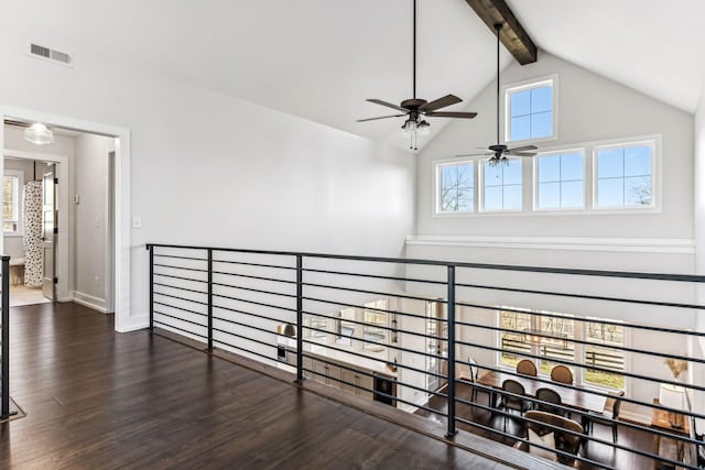 hallway featuring dark wood-type flooring, high vaulted ceiling, and beamed ceiling