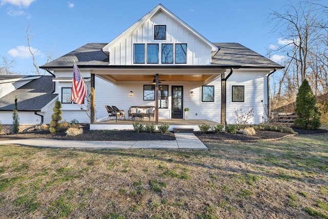 modern farmhouse with ceiling fan, a front yard, and covered porch