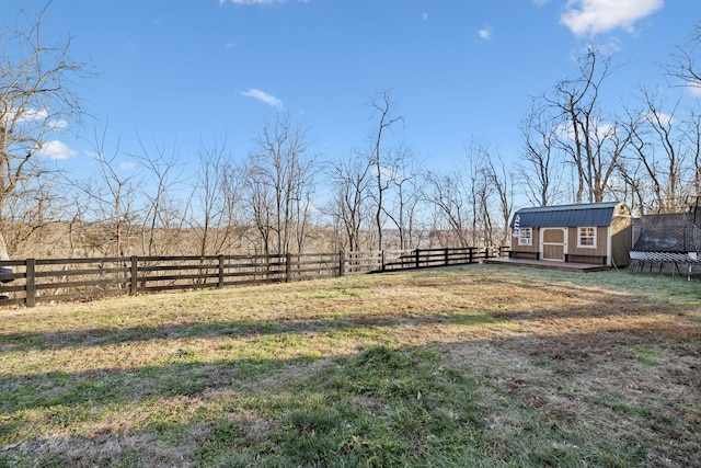 view of yard featuring a trampoline, a rural view, and a storage unit