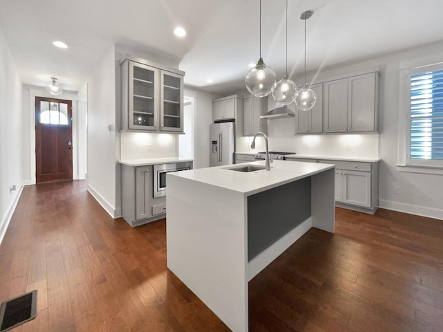 kitchen with gray cabinetry, sink, pendant lighting, and an island with sink