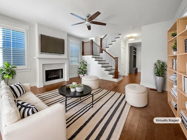 living room featuring dark wood-type flooring and ceiling fan