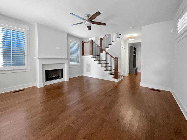 unfurnished living room with ceiling fan and dark hardwood / wood-style floors