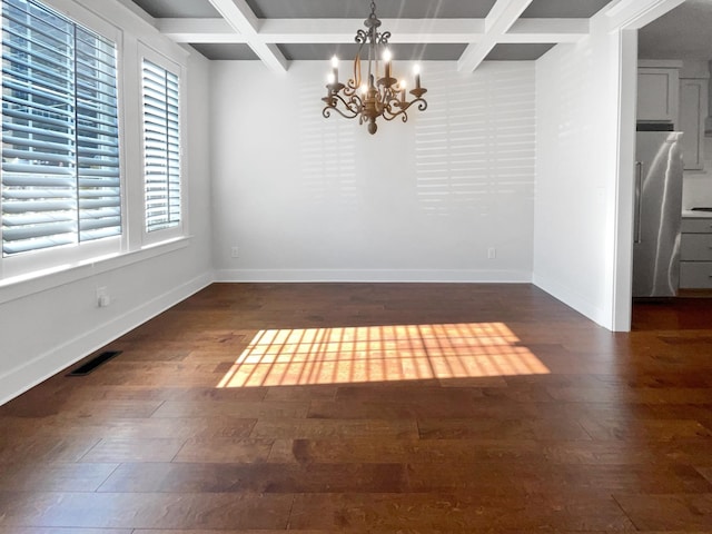 unfurnished dining area featuring beam ceiling, coffered ceiling, dark hardwood / wood-style floors, and a chandelier