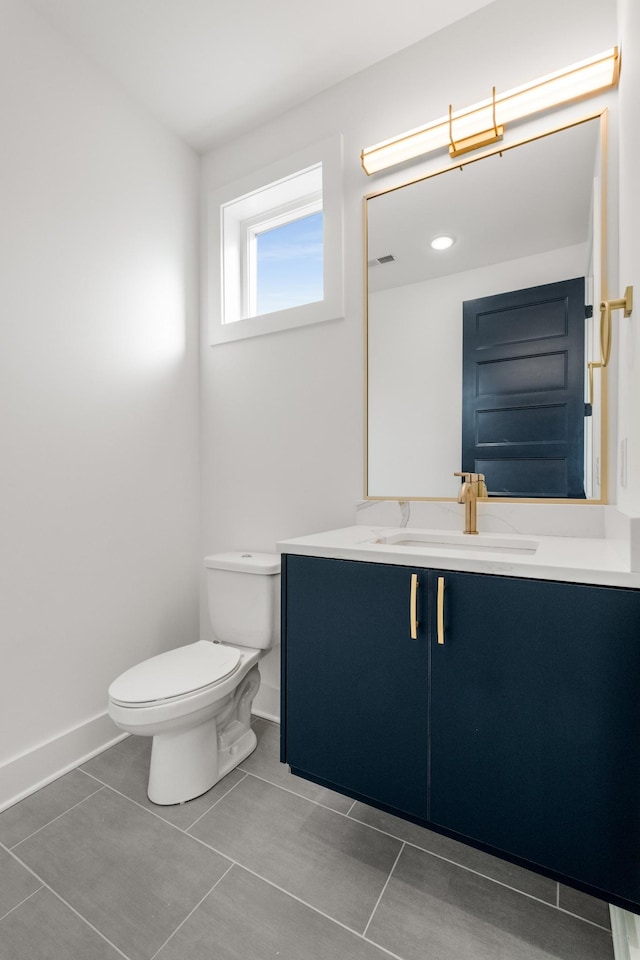 bathroom with tile patterned flooring, vanity, and toilet