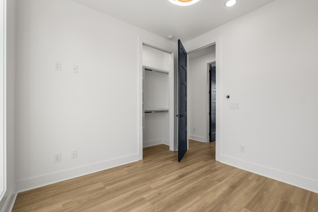 unfurnished bedroom featuring a closet and light wood-type flooring