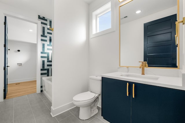 bathroom with vanity, tile patterned floors, a tub, and toilet