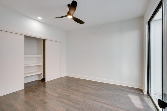 unfurnished bedroom with dark wood-type flooring, ceiling fan, and a closet