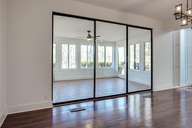 unfurnished bedroom featuring dark hardwood / wood-style floors, a closet, and a notable chandelier