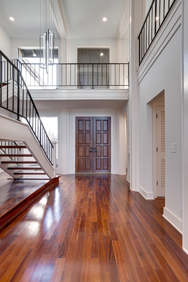 foyer with a high ceiling and dark wood-type flooring