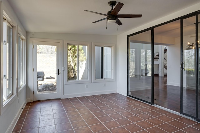 unfurnished sunroom featuring ceiling fan