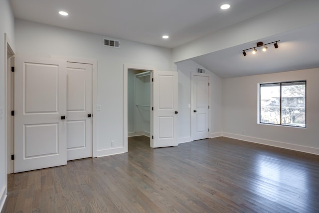 unfurnished bedroom with lofted ceiling and dark wood-type flooring