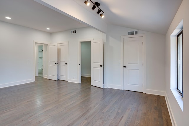 unfurnished bedroom featuring wood-type flooring and vaulted ceiling