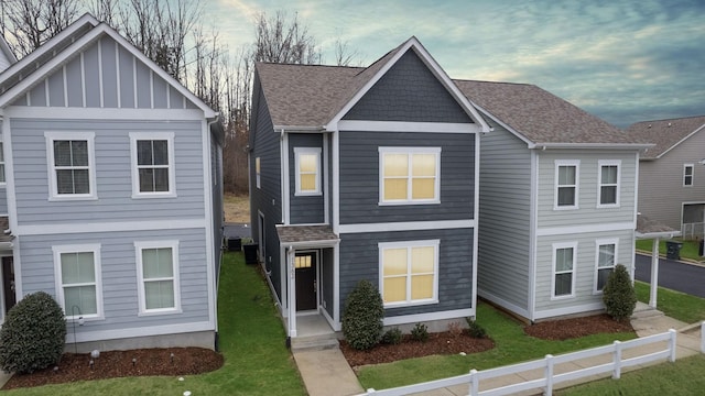 view of front of house featuring a front yard and central air condition unit