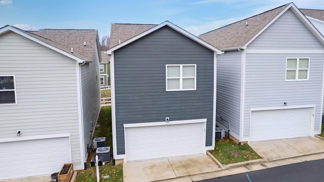 view of front of house with a garage and central AC