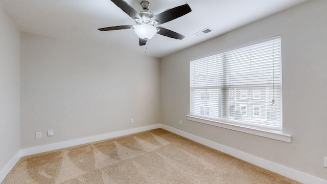 carpeted spare room featuring ceiling fan