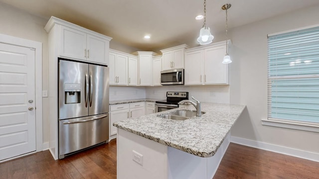 kitchen featuring white cabinetry, stainless steel appliances, decorative light fixtures, and kitchen peninsula