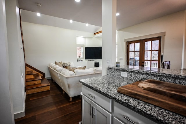 kitchen featuring french doors, lofted ceiling, dark hardwood / wood-style floors, and light stone countertops