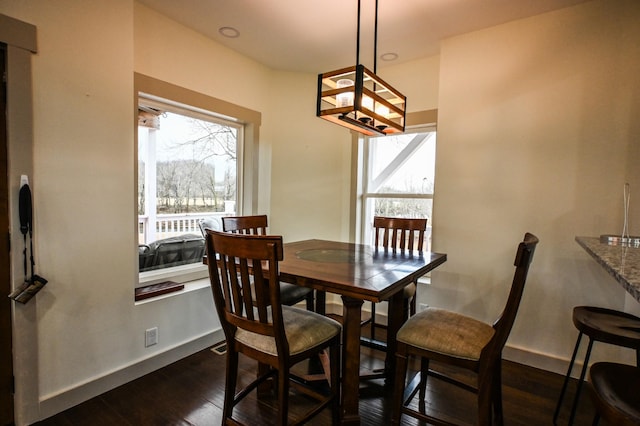 dining area featuring a notable chandelier and dark hardwood / wood-style flooring