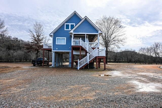 raised beach house with a porch and a carport