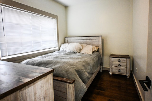 bedroom with dark hardwood / wood-style floors