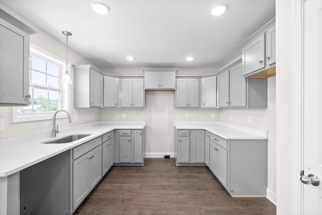 kitchen with sink, gray cabinetry, dark hardwood / wood-style flooring, and decorative light fixtures