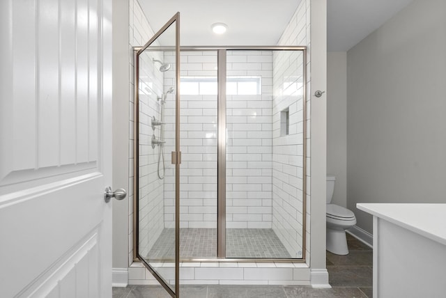 bathroom featuring an enclosed shower and toilet