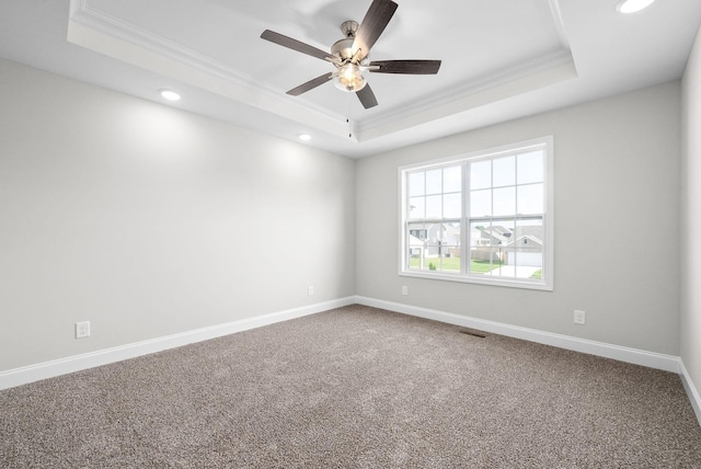 spare room with crown molding, carpet floors, ceiling fan, and a tray ceiling