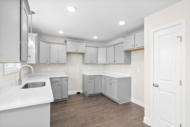 kitchen featuring sink, gray cabinetry, dark hardwood / wood-style floors, and decorative light fixtures